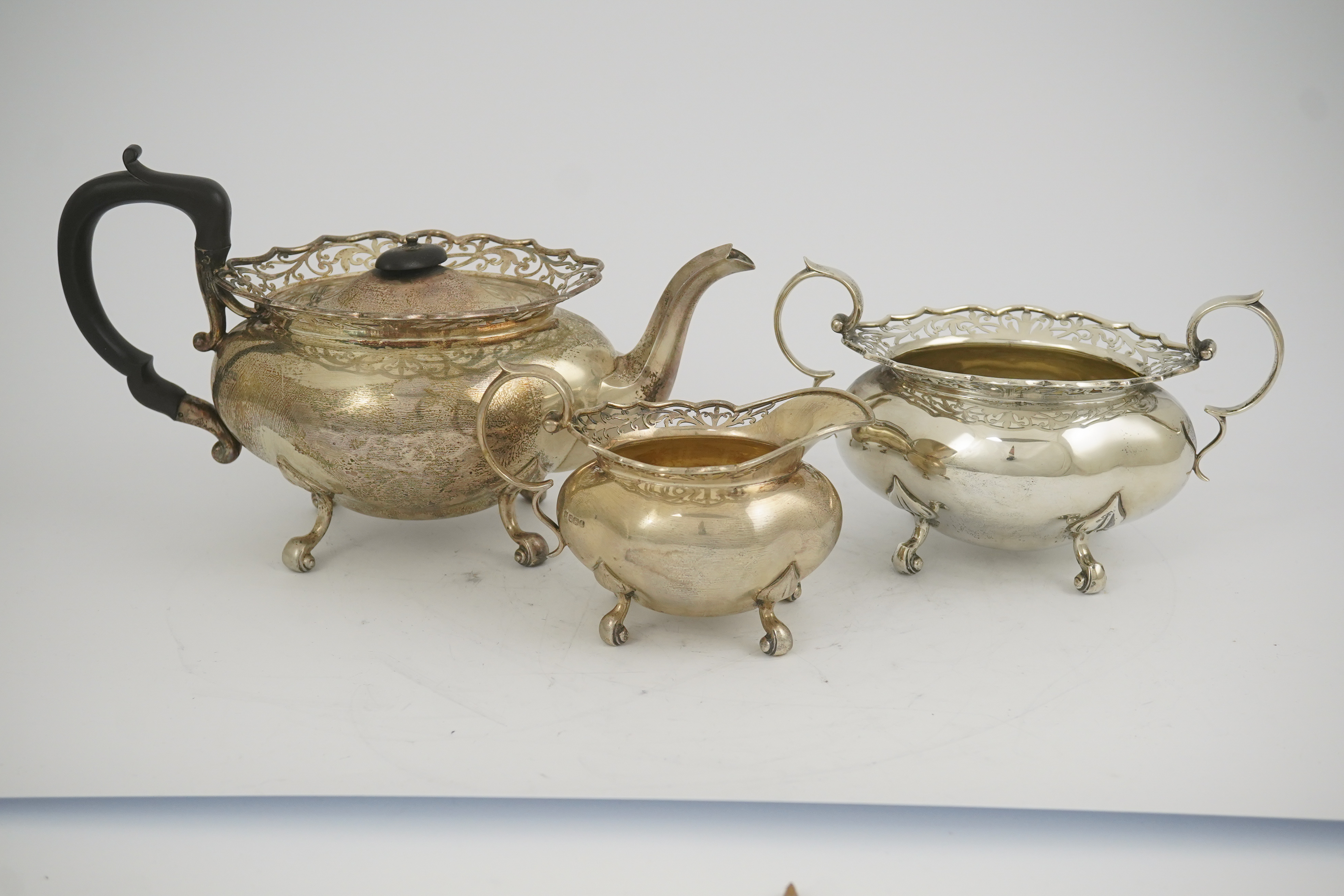 A George V three piece silver circular tea set by James Deakin & Sons